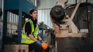 Factory worker feeling tired at the industrial manufacturing factory.